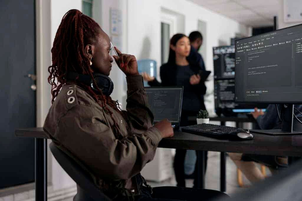 A female digital marketing expert collaborates with a group of people while working on her desktop