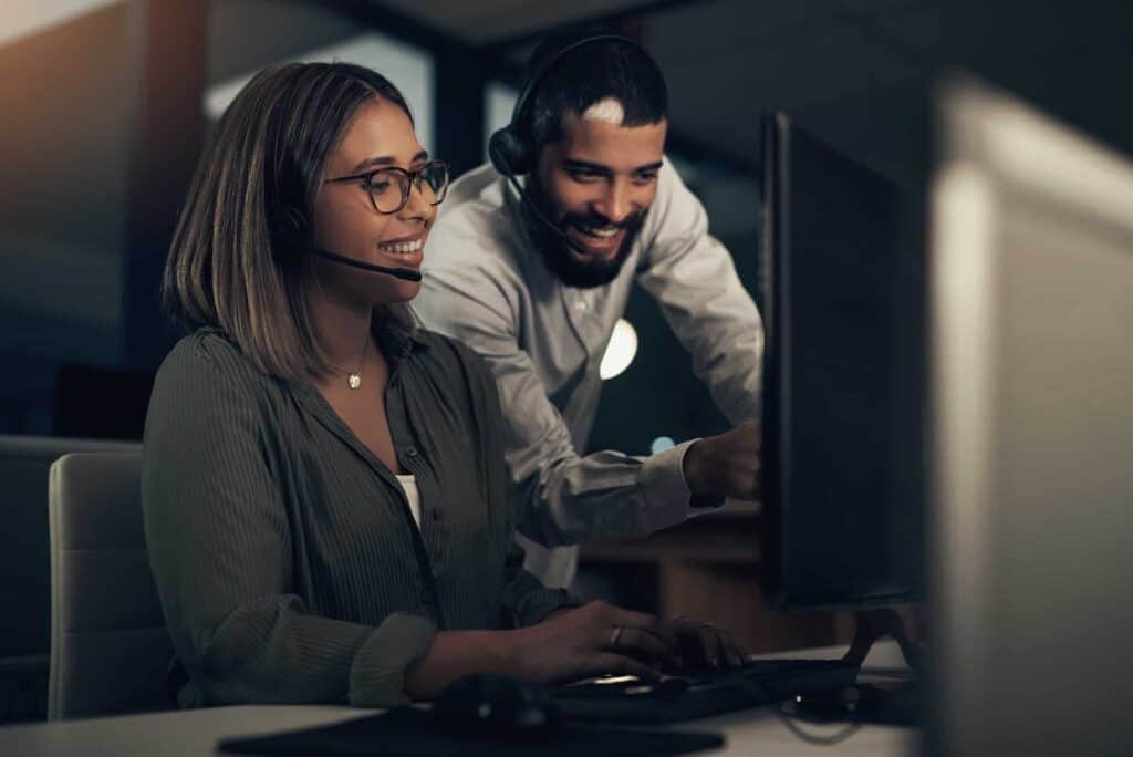 US-based digital marketing agency team working together in front of desktop screen at night